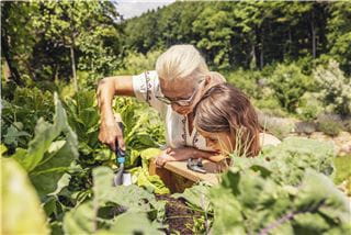 A woman and a girl working together in the garden