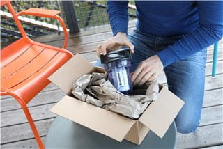 A person unpacking a package with GARDENA spare parts
