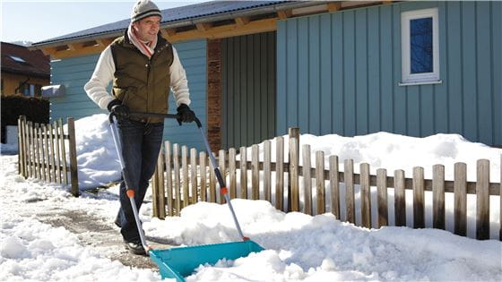 A man shoveling snow with a Gardena Snow Scoop