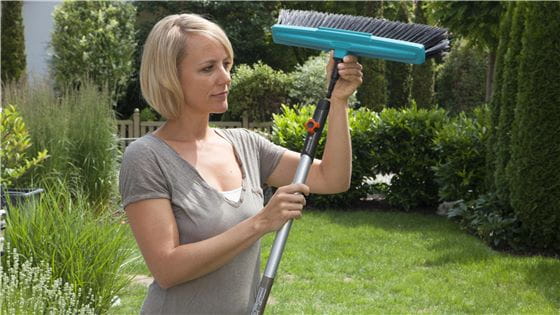 A woman adding a broom to a combisystem Handle