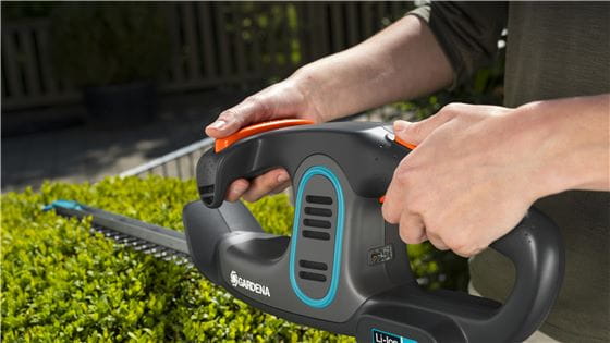 A person using the Gardena Battery Hedge Trimmer with Integrated Battery