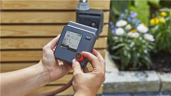 Close-up of a person using the GARDENA watering controls panel