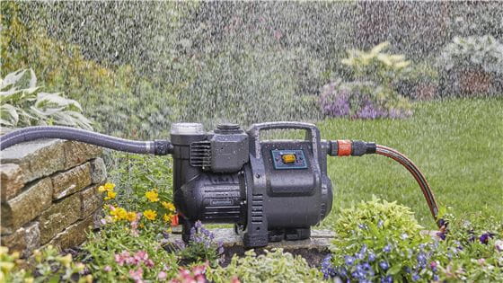 Automatic Home and garden Pump standing in a garden while it is raining outside