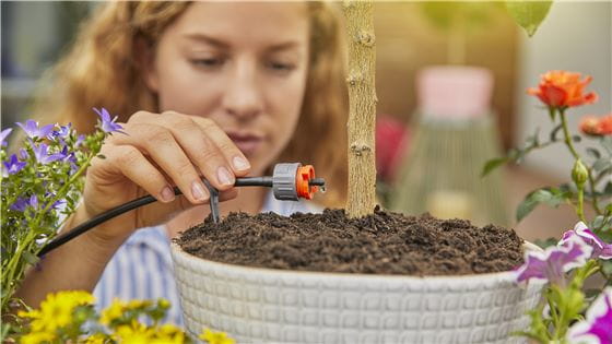 Woman installing the Gardena Micro-Drip-System in a Flowerpot