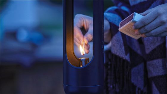 A person lighting a Gardena ClickUp Torch with some matches