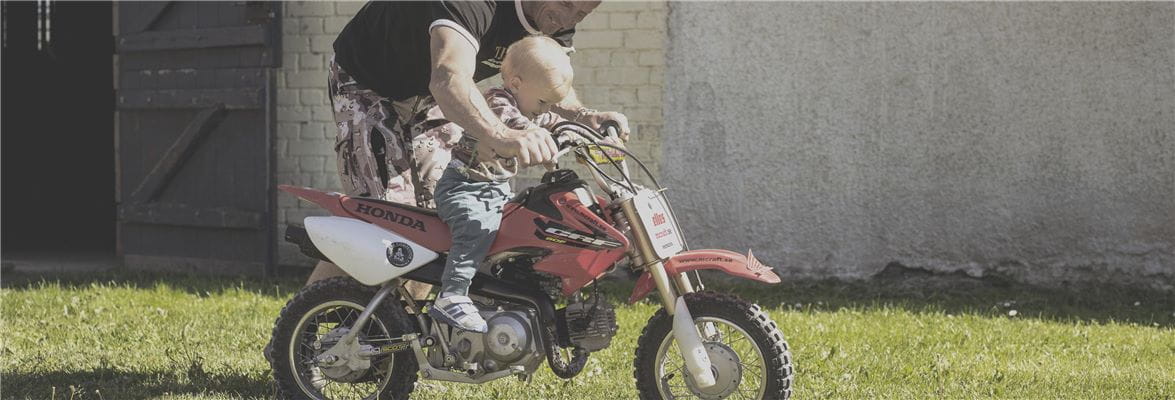 Jonsered man and child on mini motorcycle