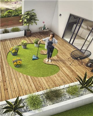 Bird's-eye view on a woman on her terrace with a handymower