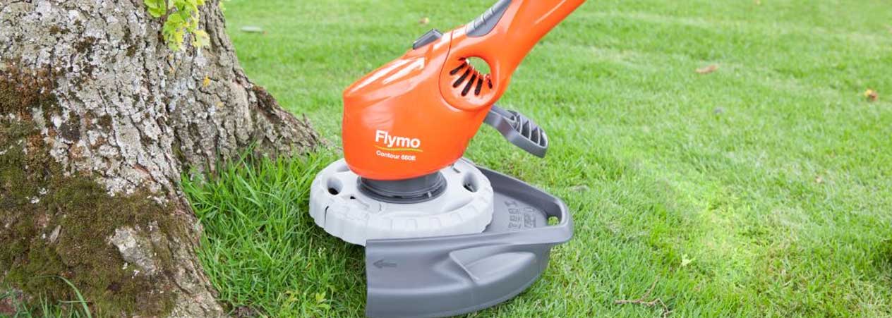 Flymo grass trimmer cutting close to tree